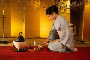 Frau im Kimono bereitet in einem japanischen Teeraum Tee zu
