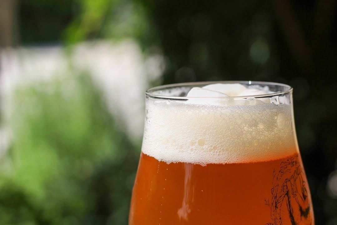 Bernsteinfarbenes Bier mit üppigem Schaum in einem Glas im Freien