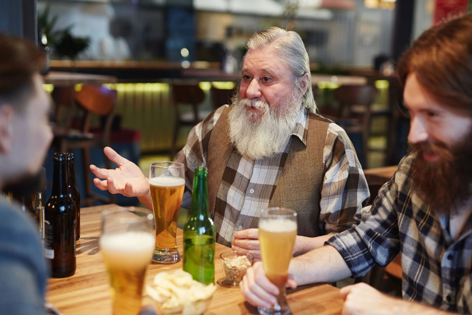 Menschen diskutieren bei Bier an einem Tisch in einer Kneipe